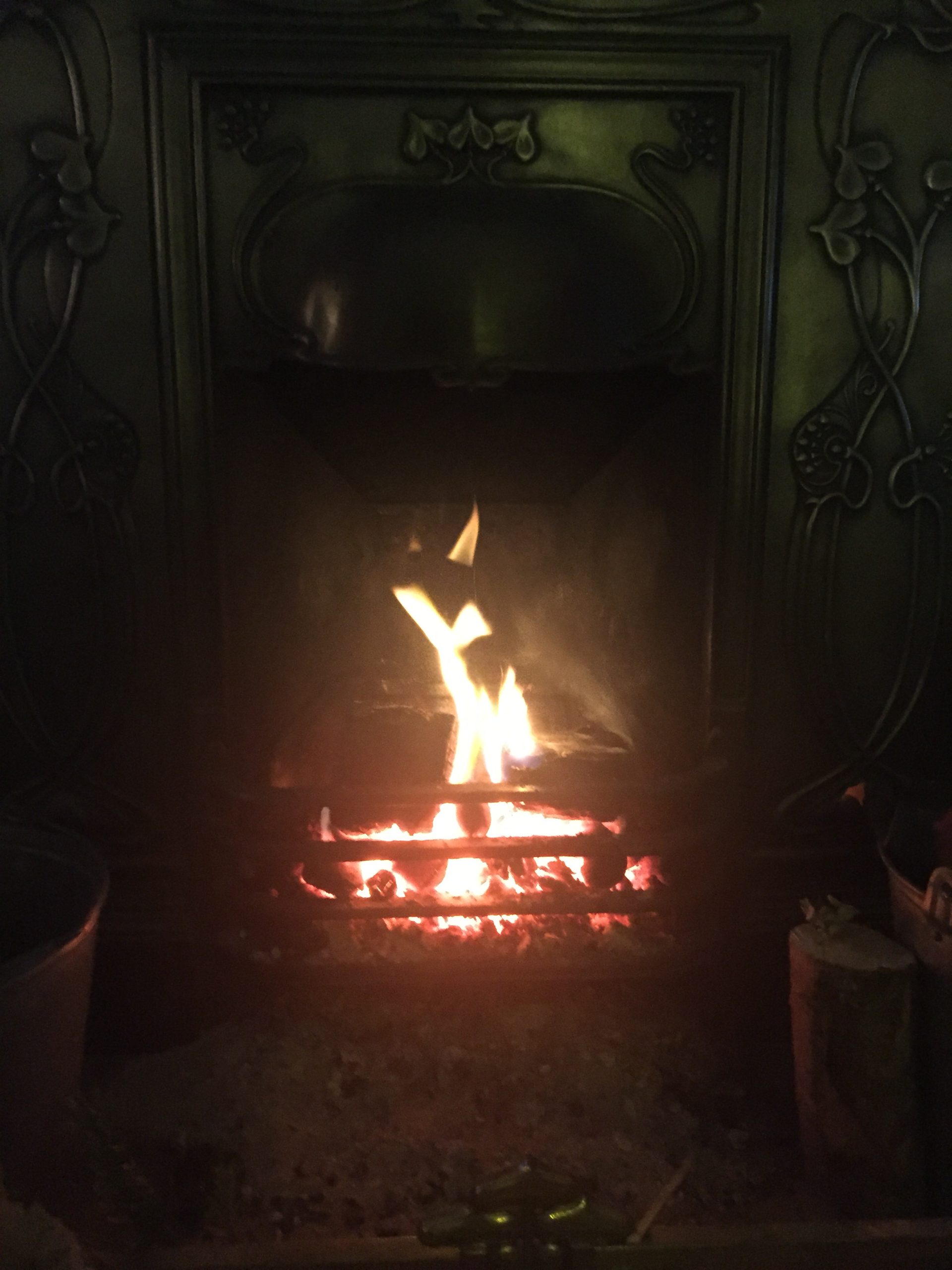 Open fire burning in the living room of Priory Cottage