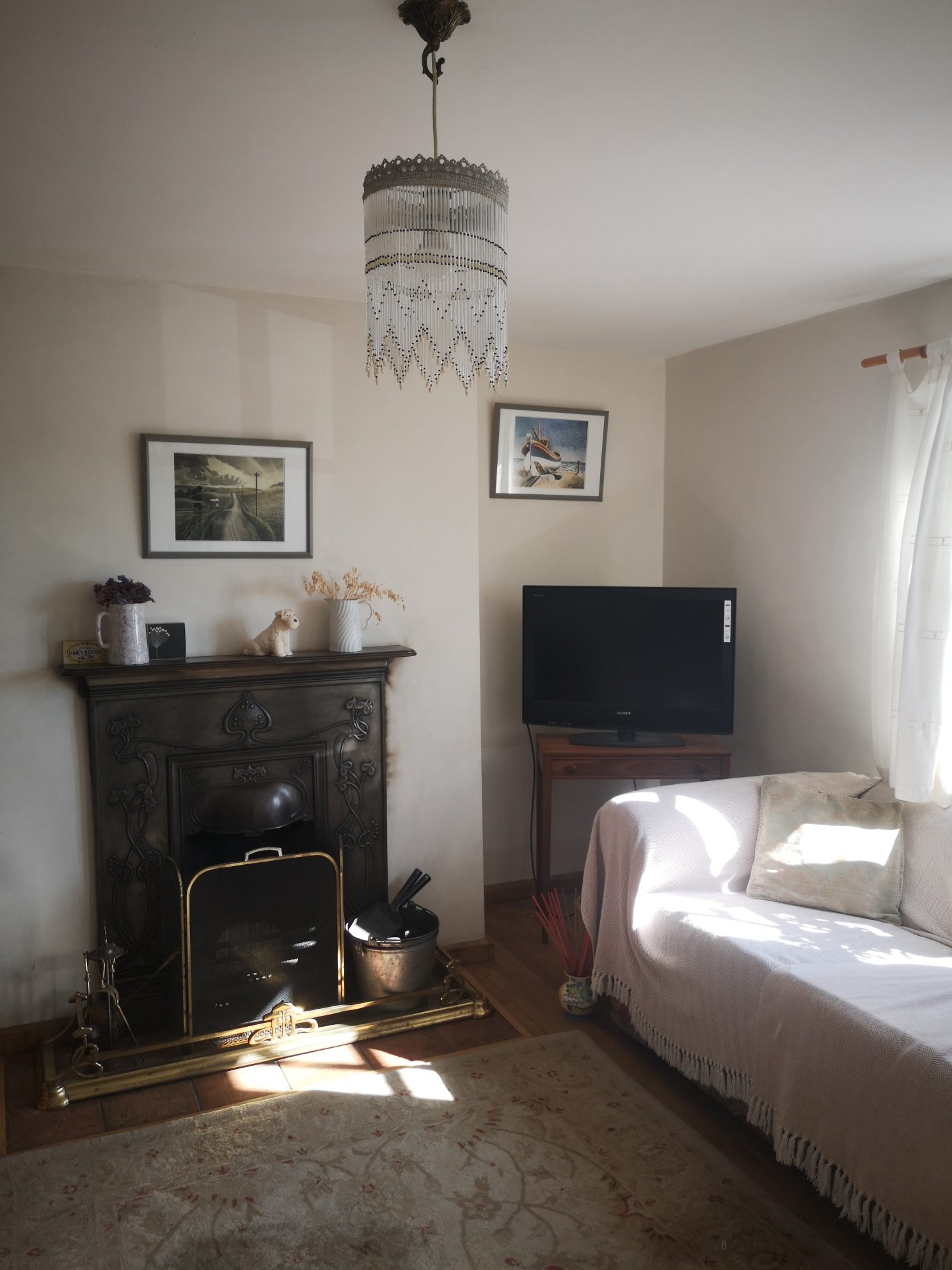 Open fireplace in the living room of the Castle Acre Holiday Cottage